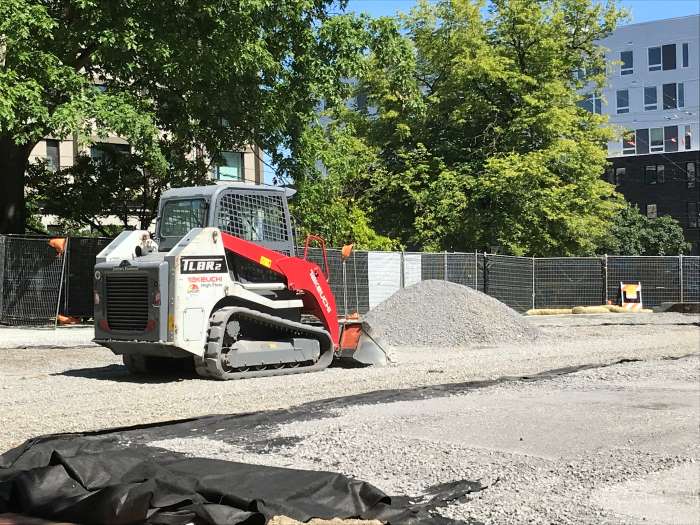 Bulldozer moves and smooths gravel